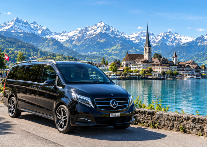 Private Mercedes V-Class touring through a spring alpine valley with Swiss chalets and snow-capped mountains on the 10-Day Swiss Spring Tour.